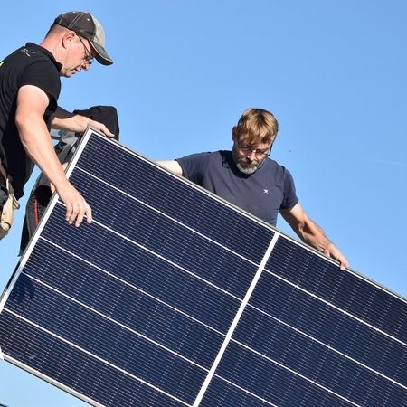 Photovoltaikanlage wird von 2 Mitarbeitern getragen